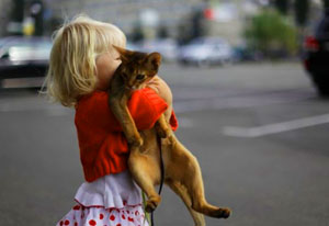 Девочка выгуливает кошку
